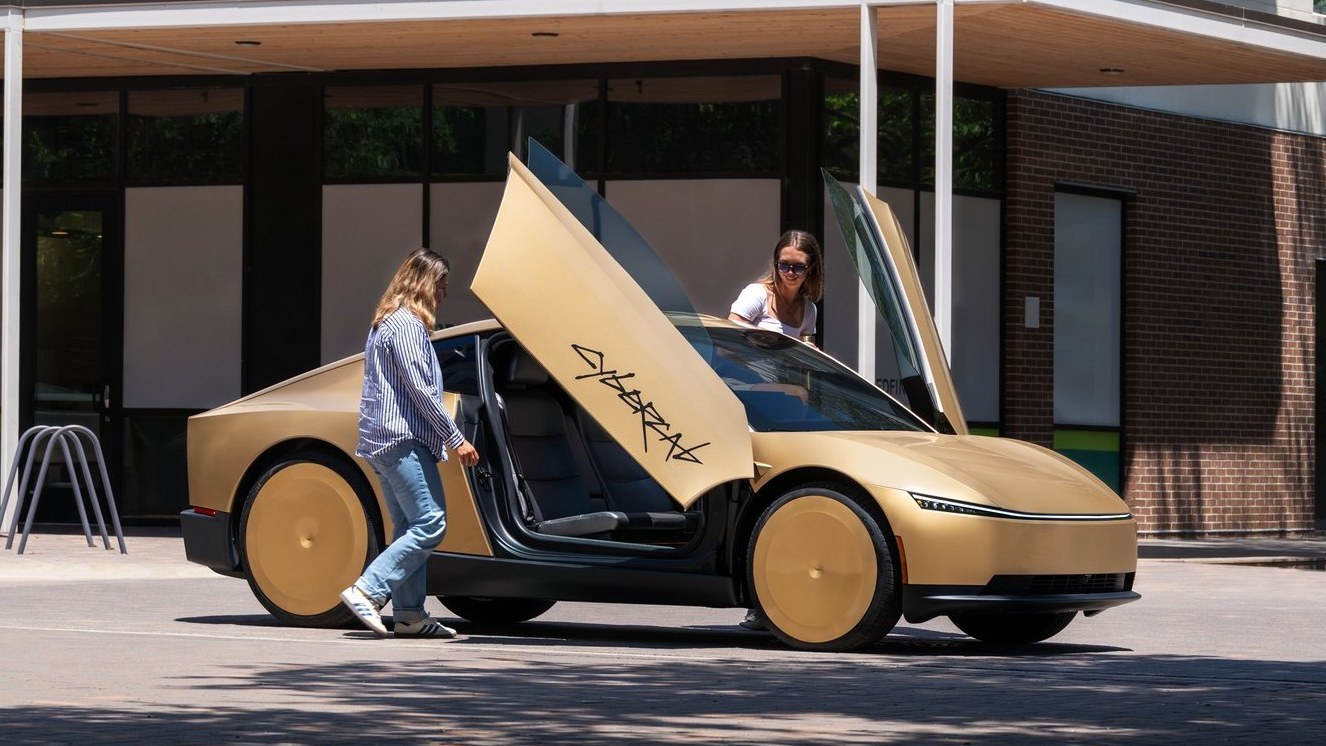 Gold Tesla Cybercab with butterfly doors open on a city street
