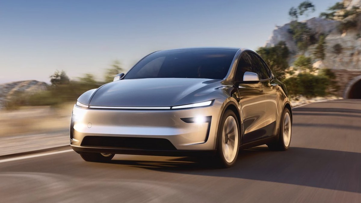 Silver Tesla Model Y driving on a mountain road
