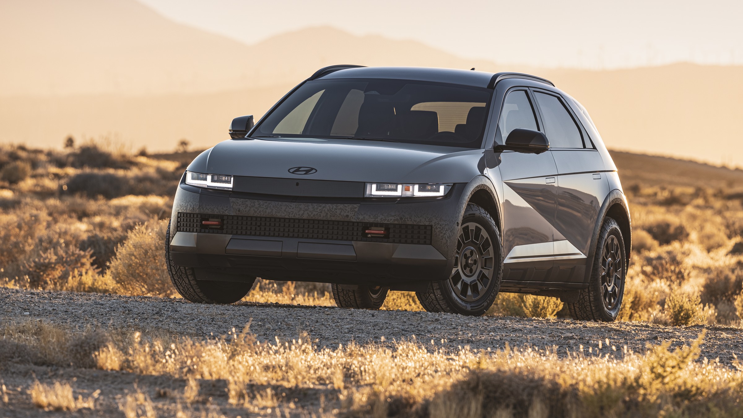 Gray Hyundai Ioniq 5 XRT on a desert gravel road at sunset