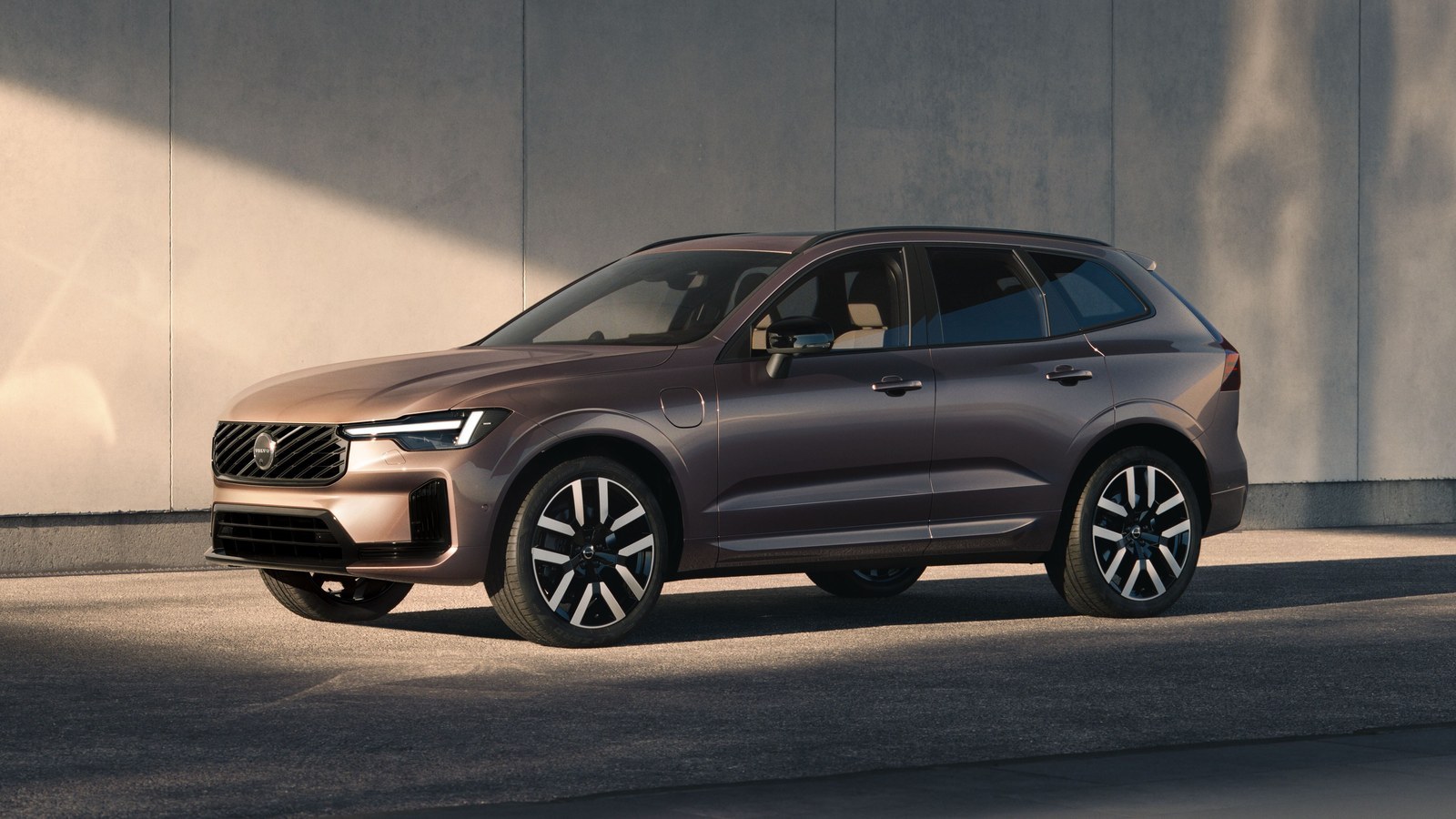 Bronze Volvo XC60 parked beside a concrete wall