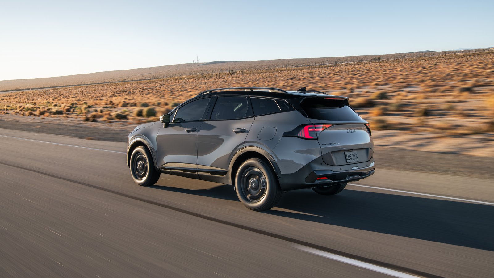 Rear three-quarter view of 2027 Kia Sportage X-Line on a desert highway