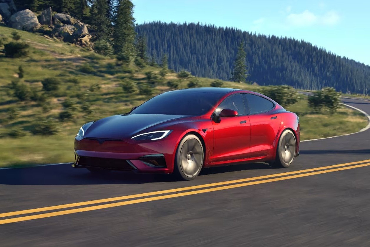 Red Tesla Model S driving on a mountain road
