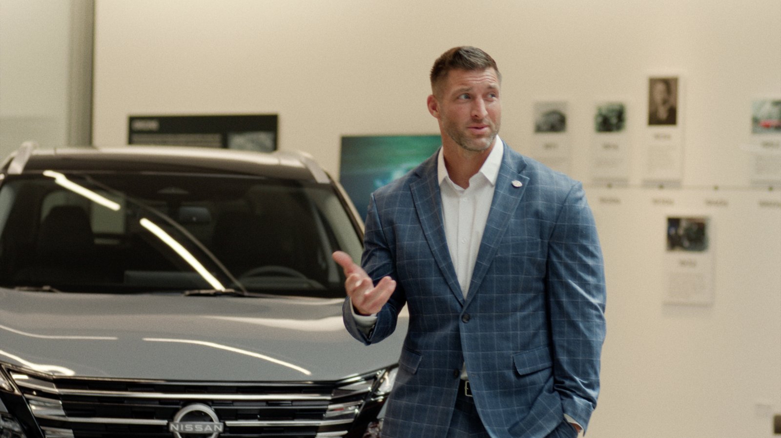 Tim Tebow standing next to a Nissan Rogue in a scene from the Tell Them a Heisman Sent You campaign