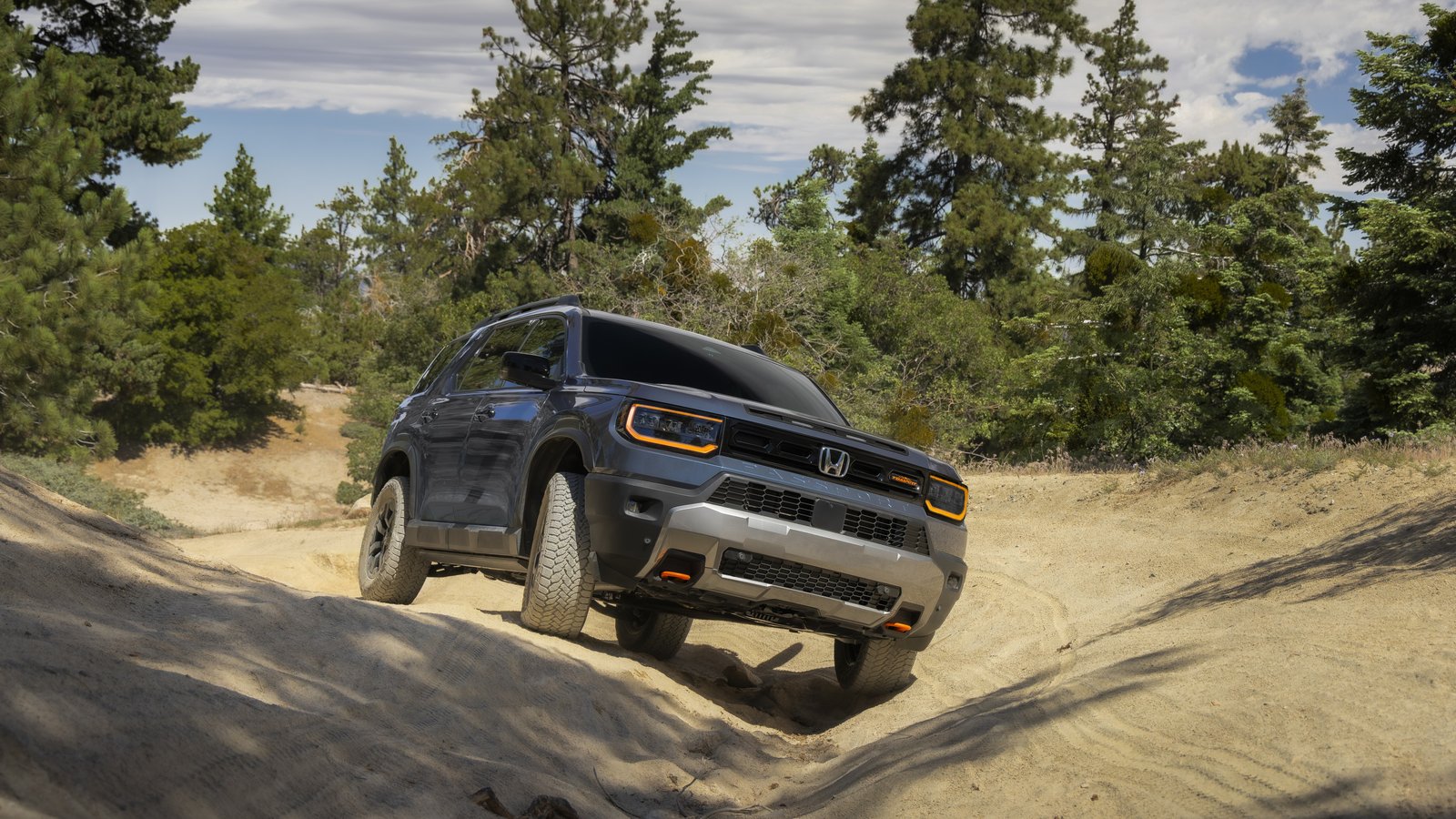 Honda Passport TrailSport articulating over uneven ground on a forest trail