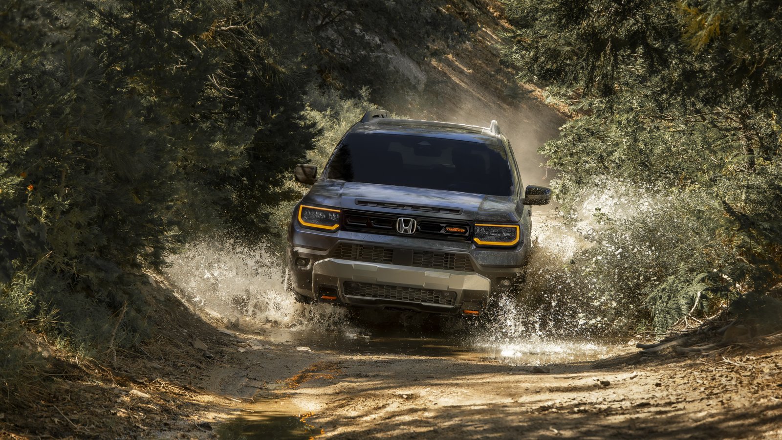 Honda Passport TrailSport splashing through a wooded trail, front view
