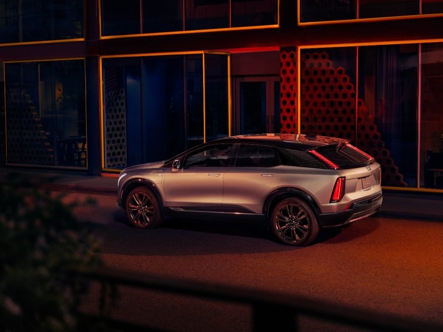 Silver Cadillac Optiq electric SUV parked on a city street at night
