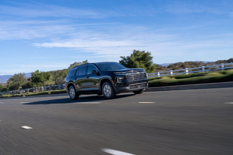 Black 2026 Chevrolet Suburban driving on a paved highway