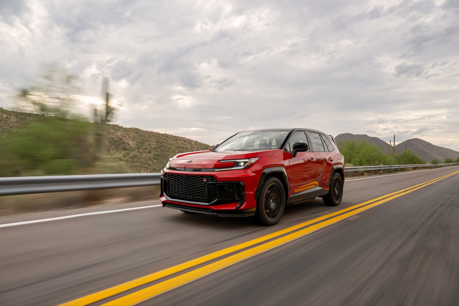Red Toyota RAV4 GR SPORT plug-in hybrid driving on a desert highway