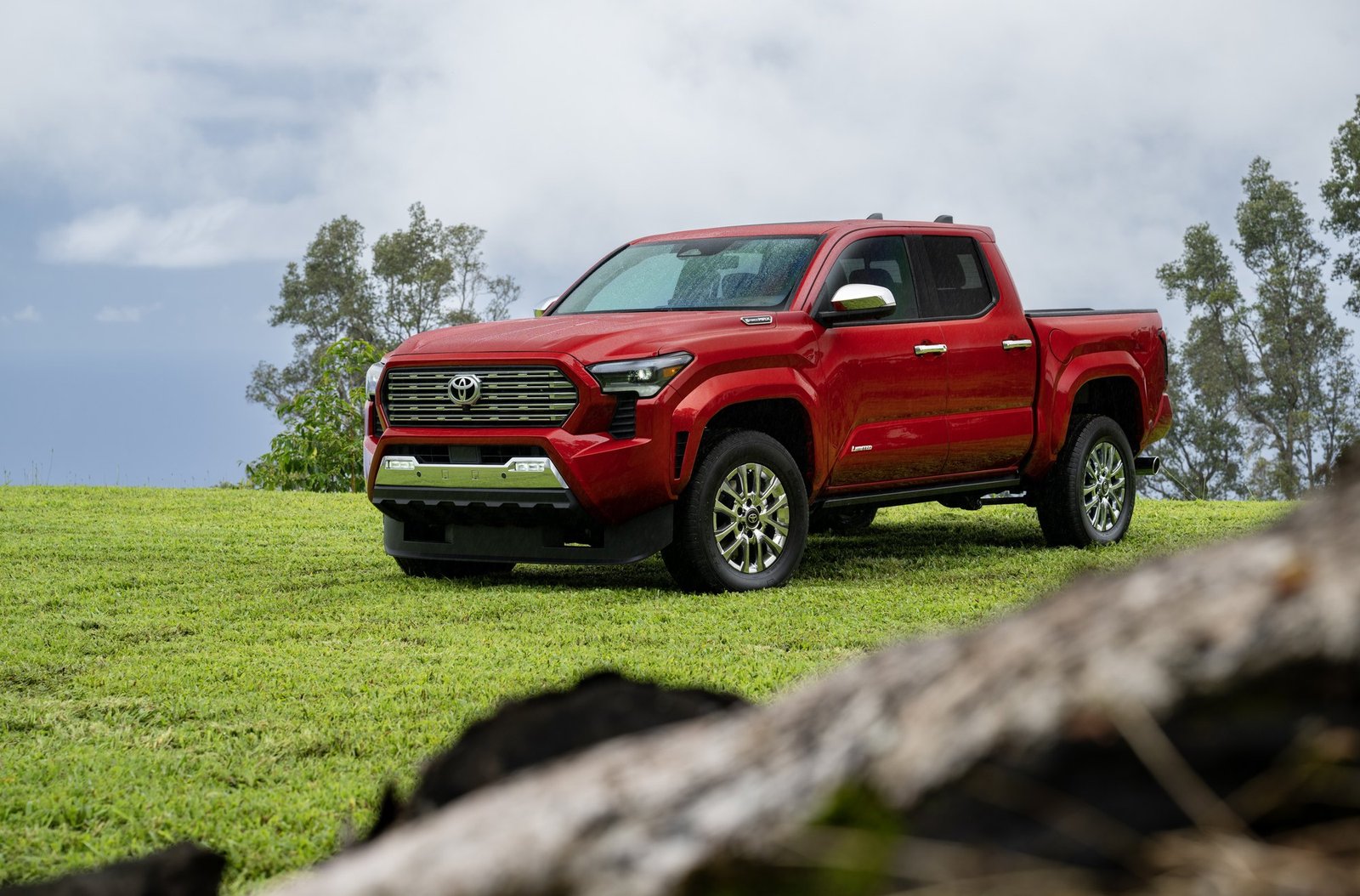 2026 Toyota Tacoma Limited Double Cab in red parked on a grassy hill