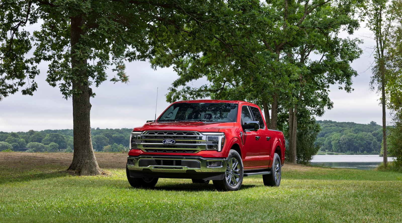 Red 2027 Ford F-150 Lariat front three-quarter view under trees