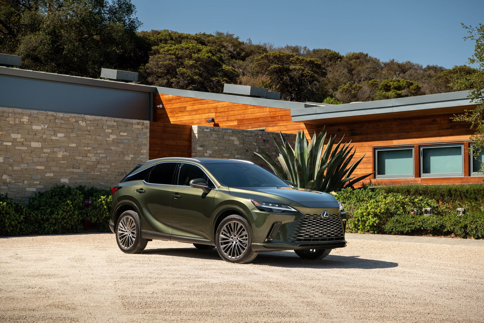 2027 Lexus RX 350h Luxury in Nori Green Pearl parked outside a modern house