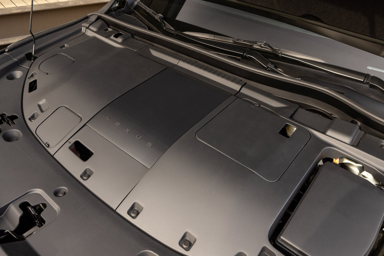 Under-hood compartment of the 2027 Lexus TZ with Lexus-branded cover