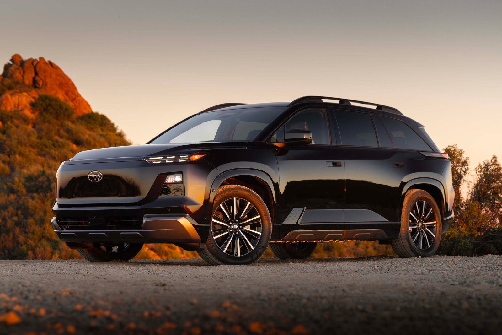 Black Subaru Getaway three-row electric SUV parked on gravel at sunset