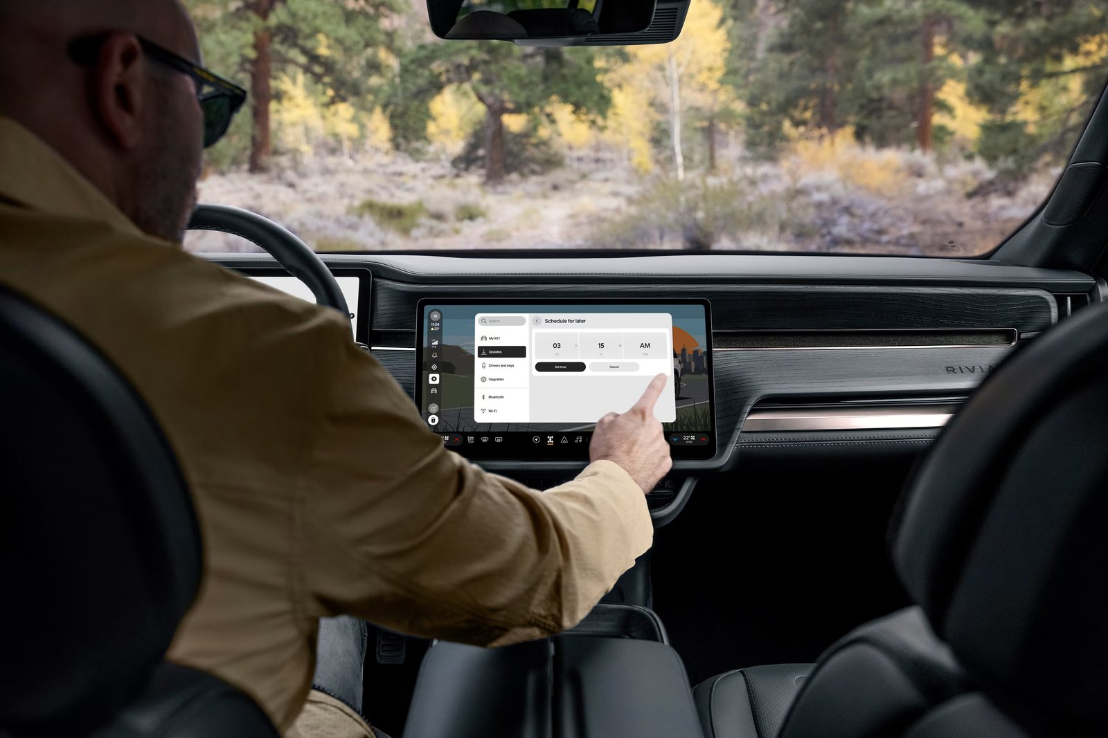 Rivian R1 driver scheduling a software update on the center display