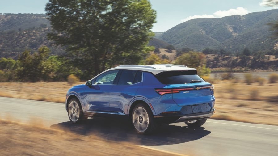 Blue 2026 Chevrolet Equinox EV driving on a rural road