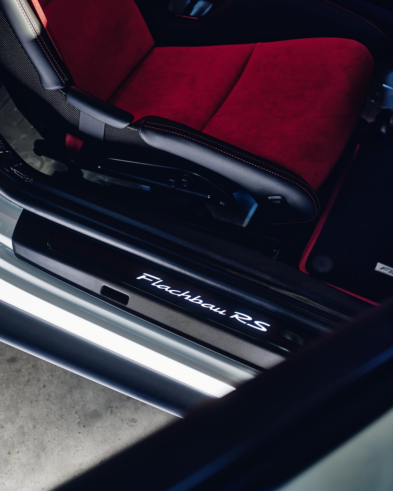 Illuminated Flachbau RS door sill and red Alcantara bucket seat