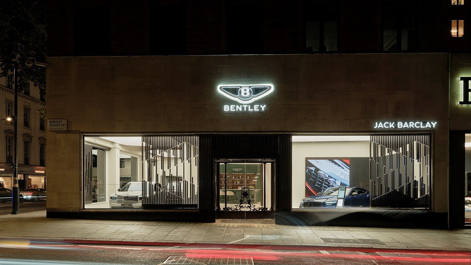 Bentley Jack Barclay showroom façade at night with illuminated winged badge