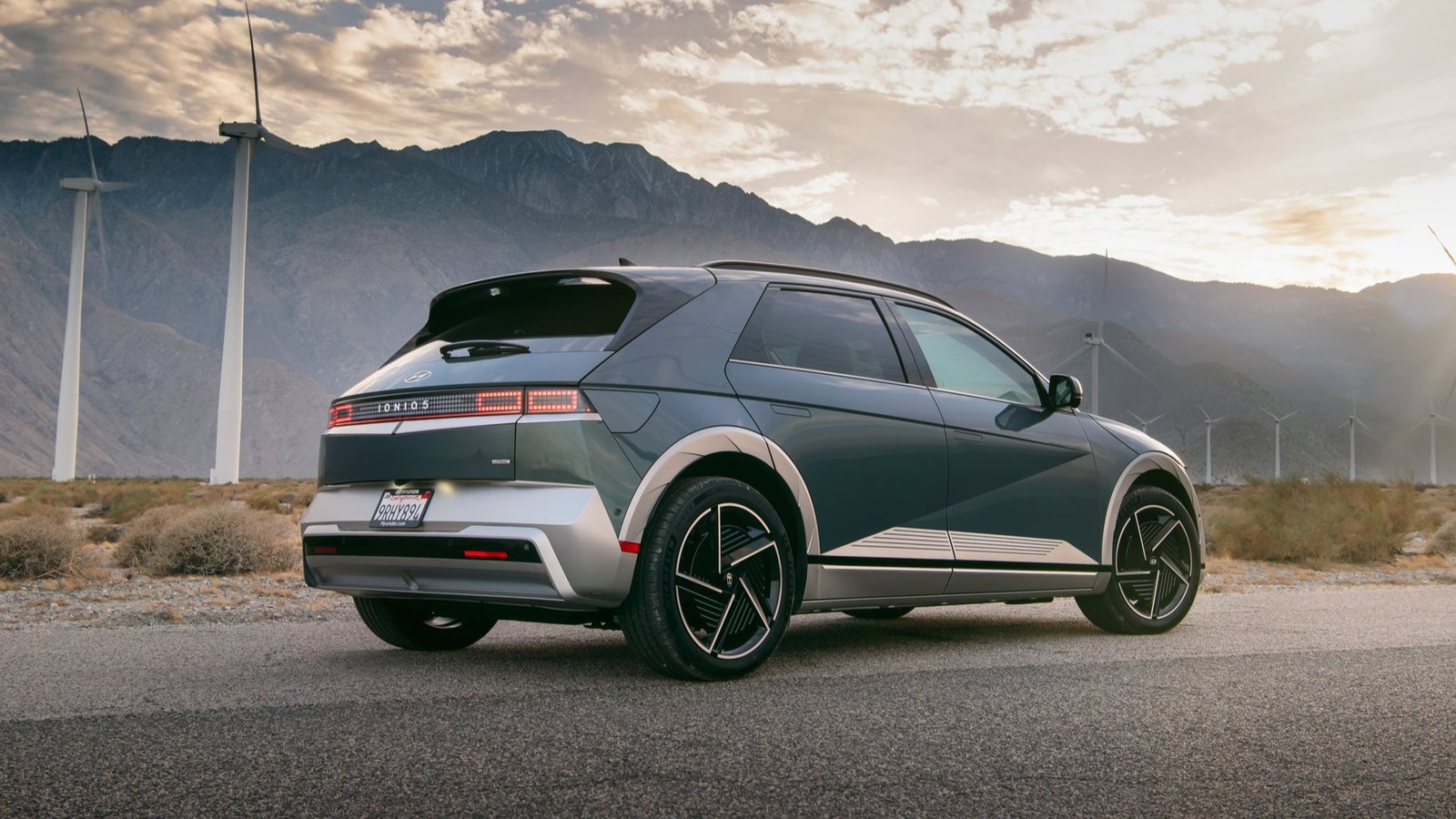 Rear view of a 2026 Hyundai Ioniq 5 Limited with wind turbines behind