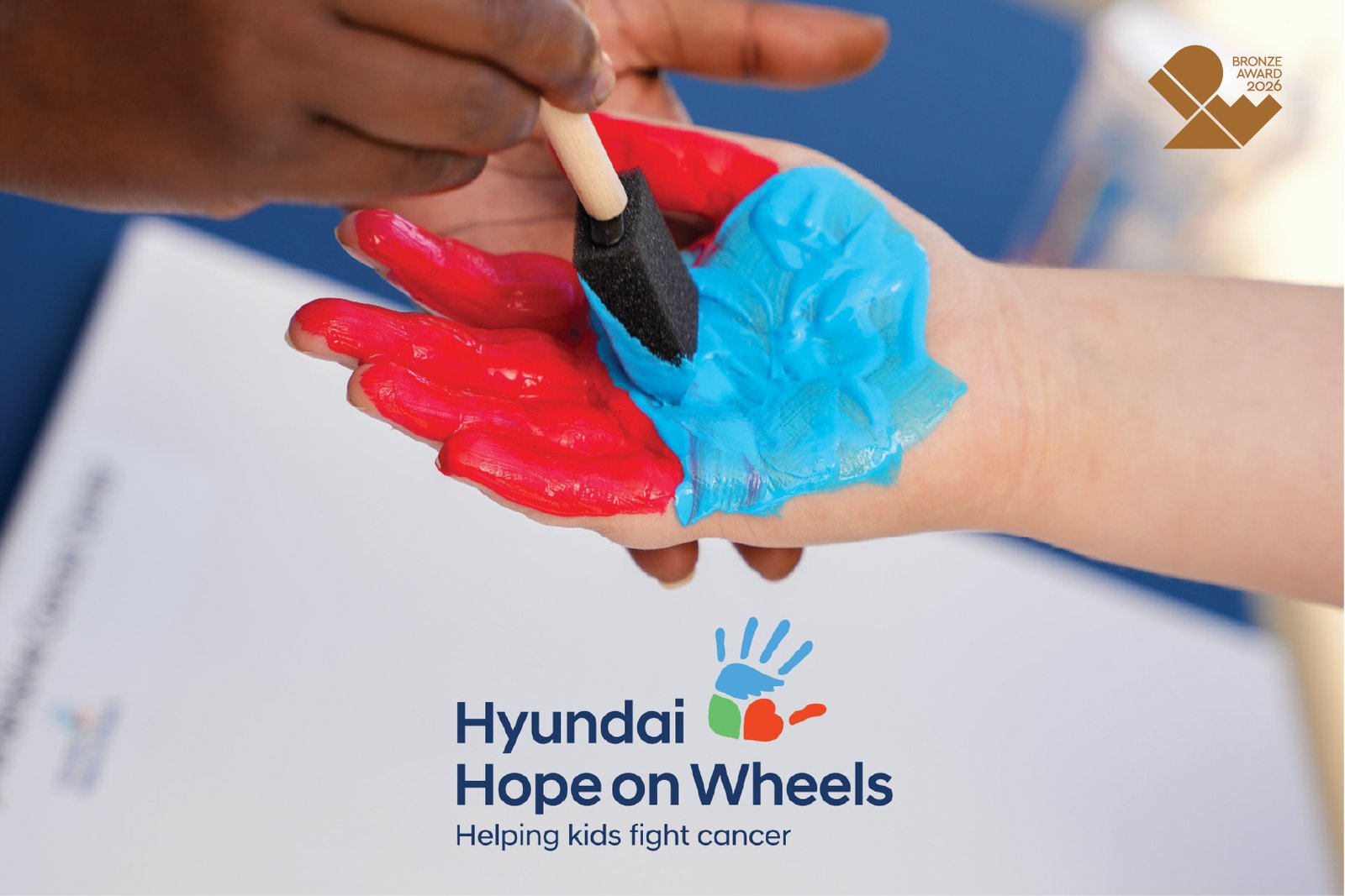 Child's hand painted red and blue at a Hyundai Hope on Wheels event