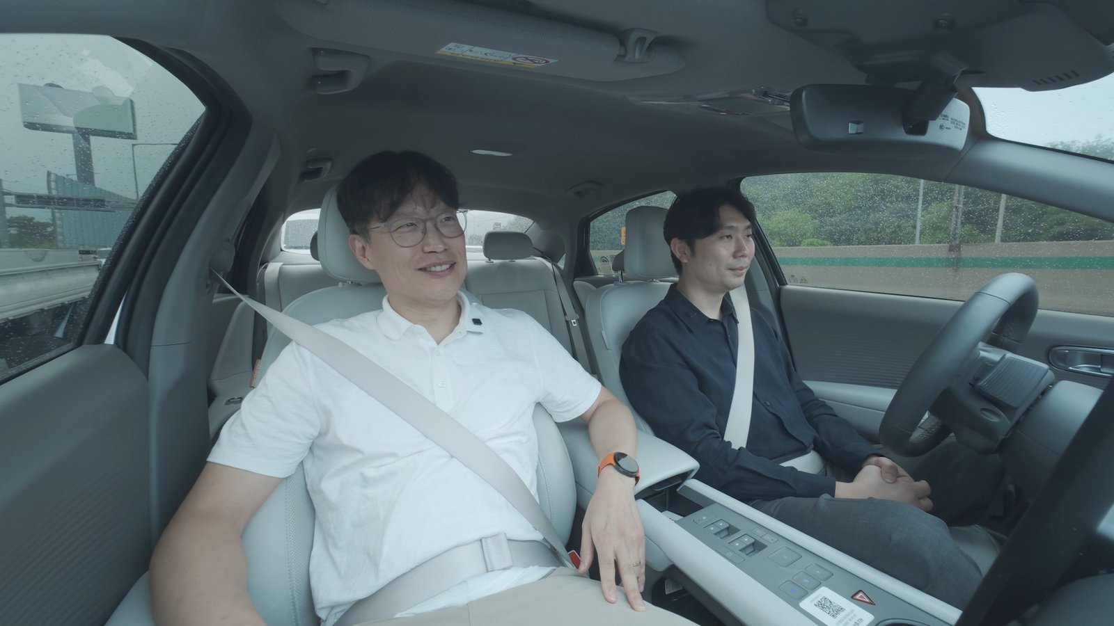 Engineers working on laptop beside Hyundai autonomous test vehicle