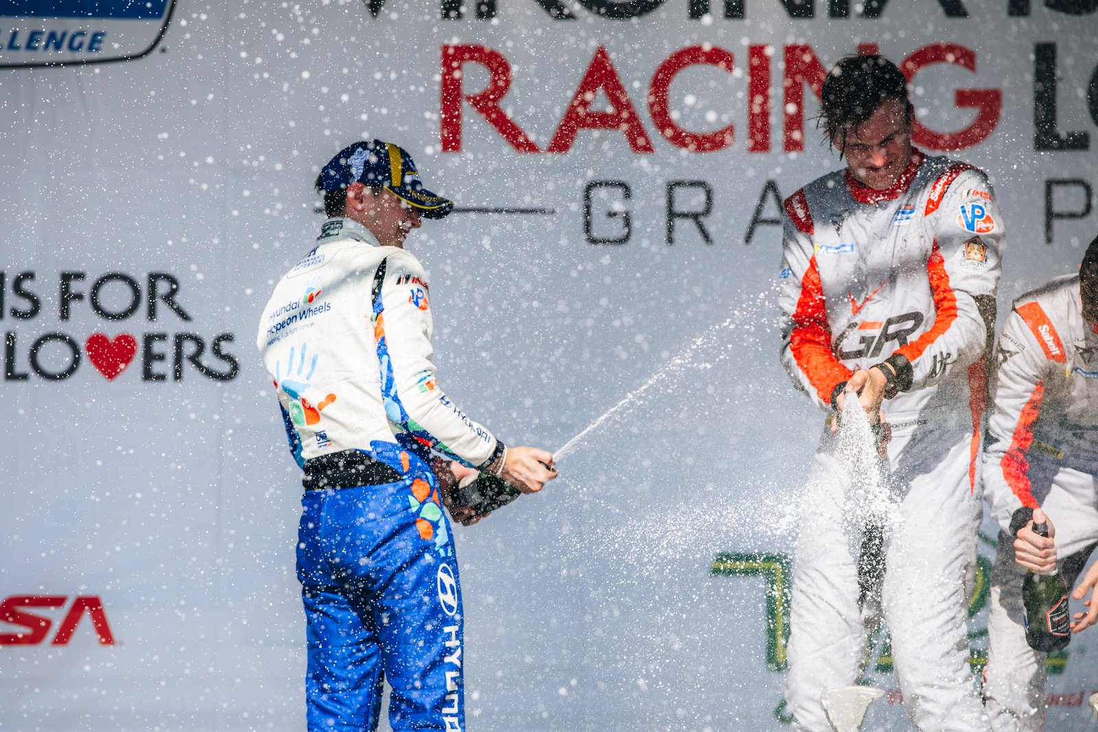 Bryan Herta Autosport driver spraying champagne on VIR podium