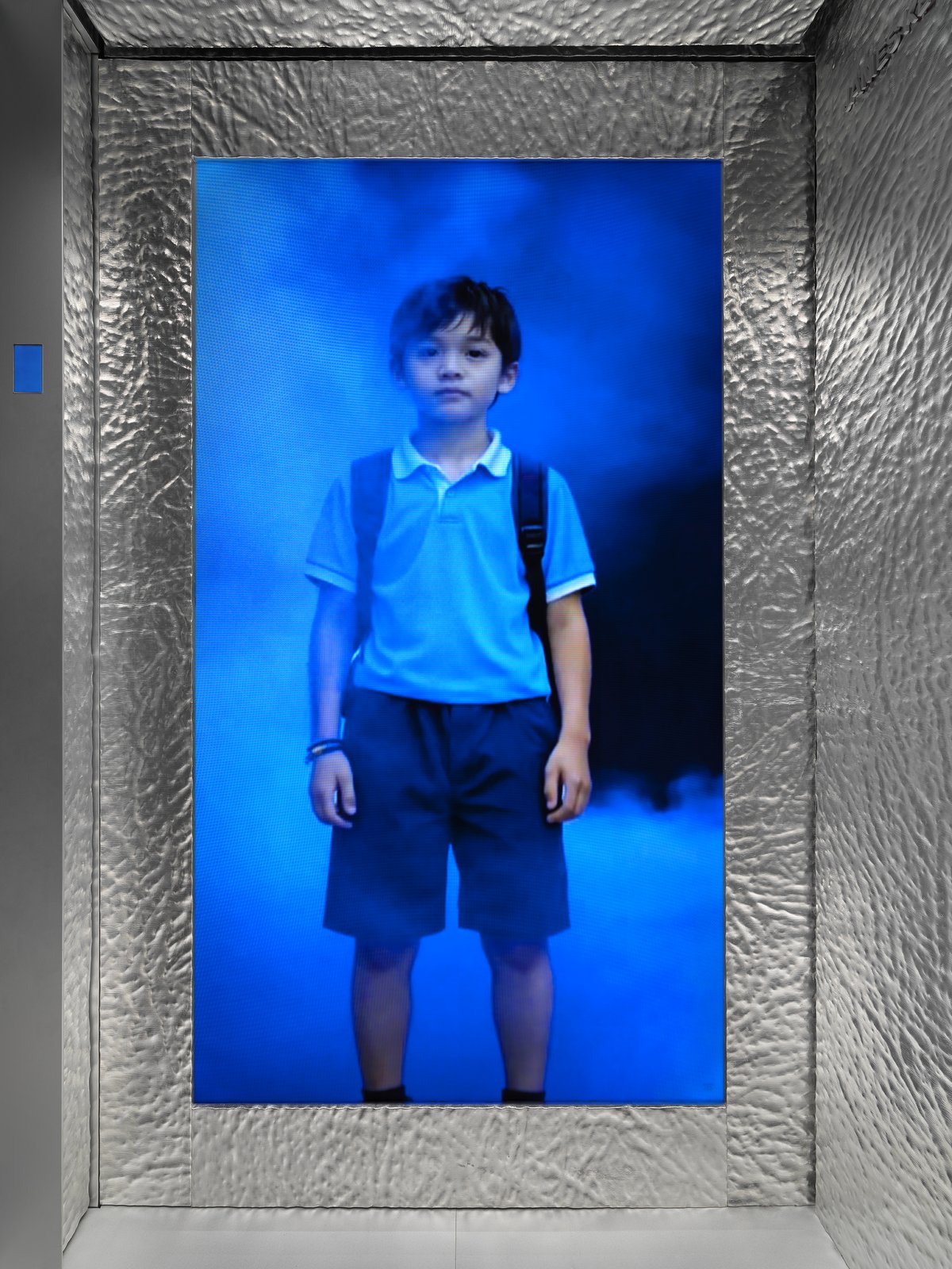 Child protagonist on elevator screen in Ho Tzu Nyen's P for Power