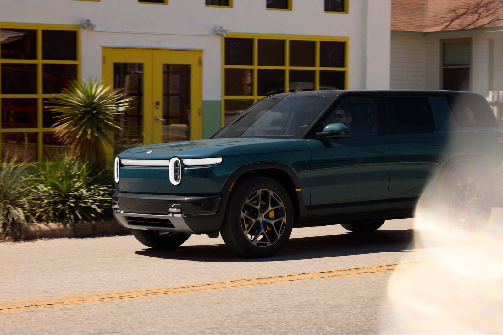 Rivian R2 driving on pavement on 21-inch all-season wheels