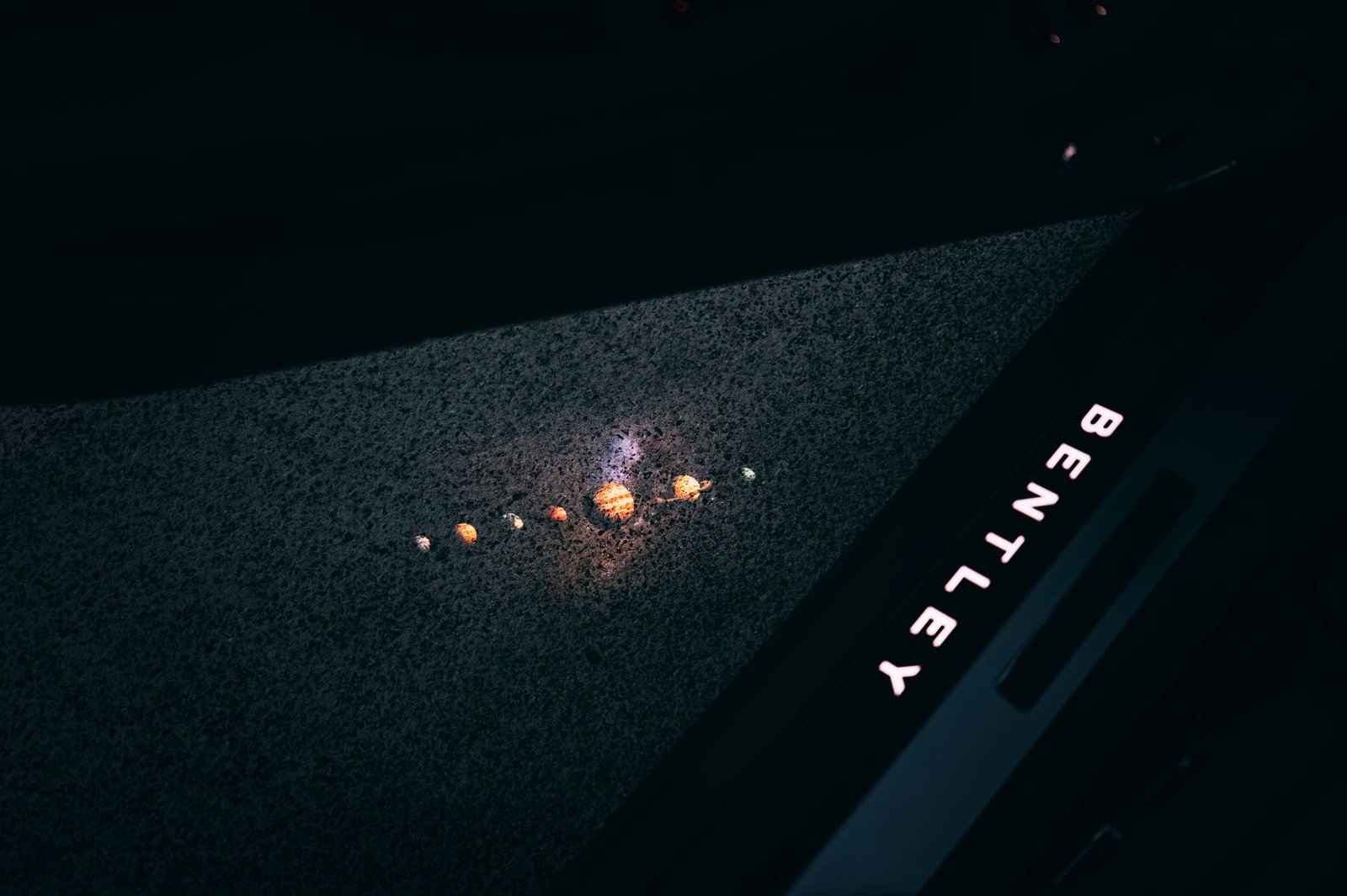 Bentley welcome lamp projecting the solar system beside the treadplate