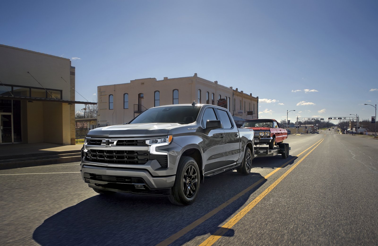 2026 Chevrolet Silverado 1500 RST towing a classic car on a trailer