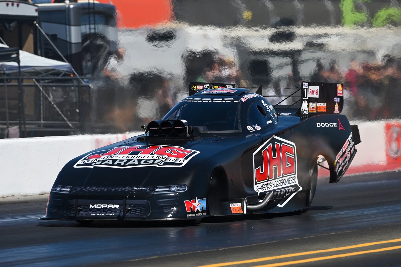 Matt Hagan's black TSR Dodge Funny Car launching during a 2026 NHRA event