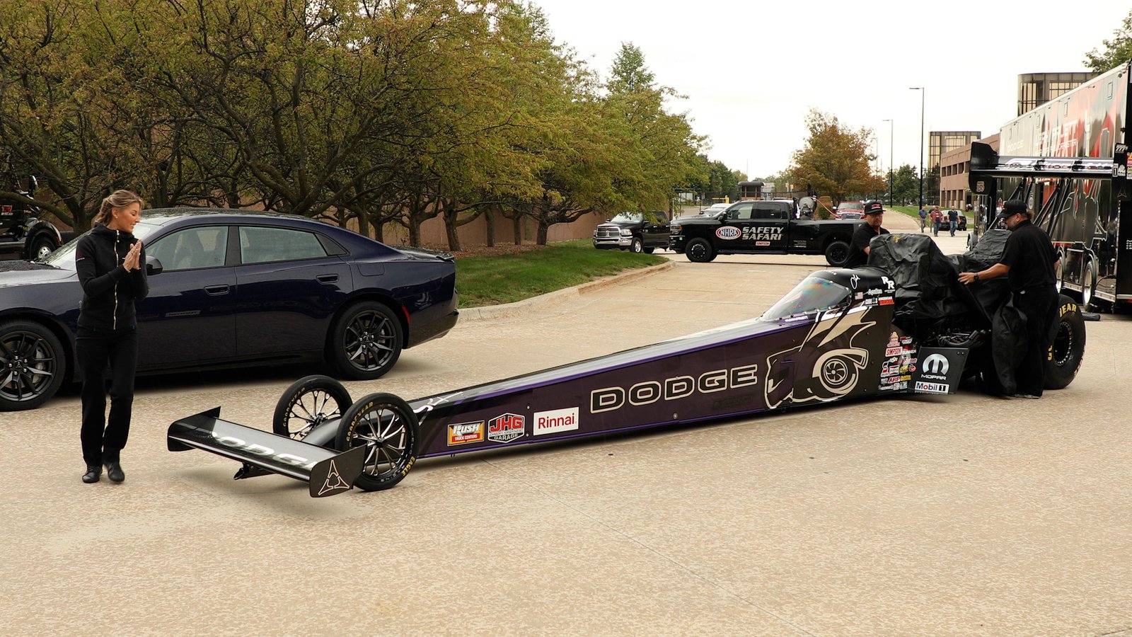 Leah Pruett unveils Purple Haze TSR Dodge Top Fuel dragster beside a Purple Haze Charger
