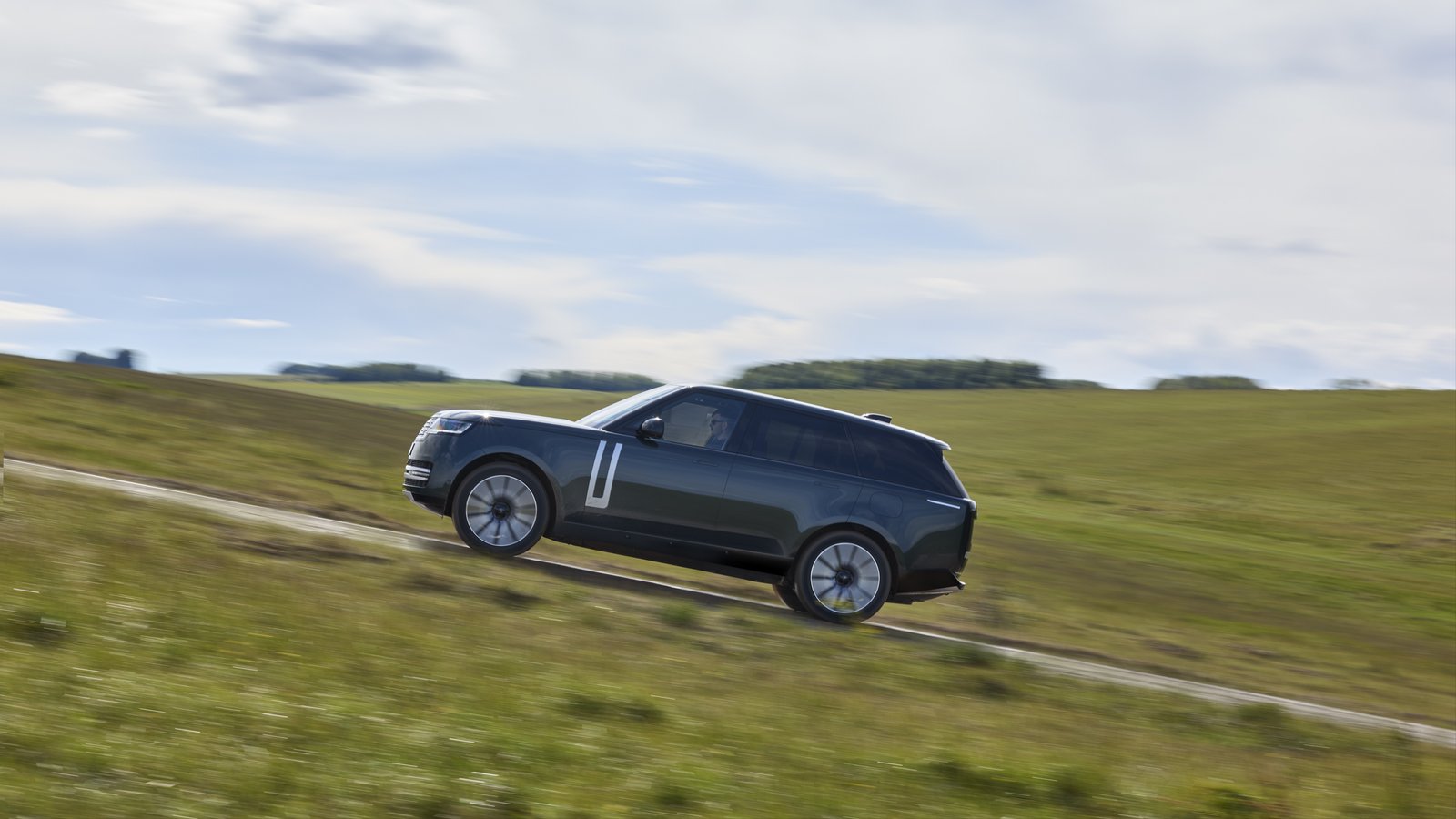 Range Rover Electric driving on grassy off-road track
