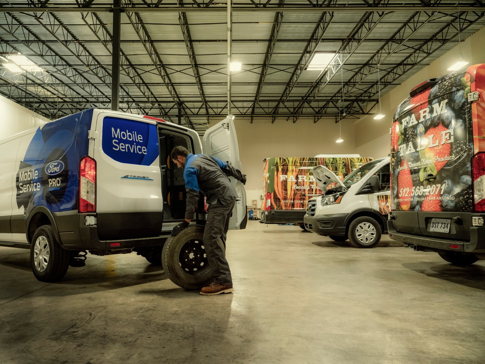 Ford Pro Mobile Service technician unloading a tire from an E-Transit