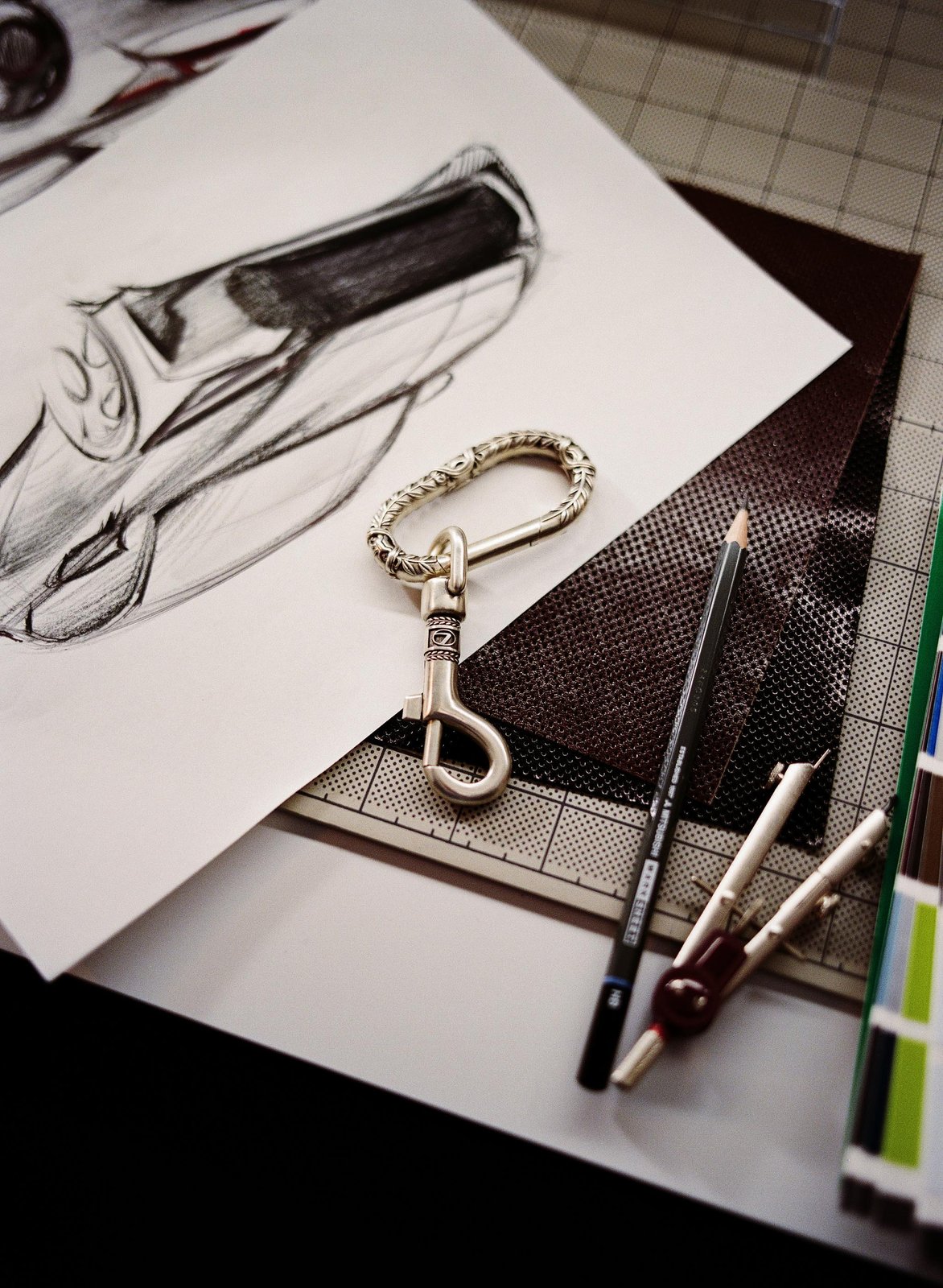 Engraved chrome Lexus AMBUSH carabiner on car design sketches