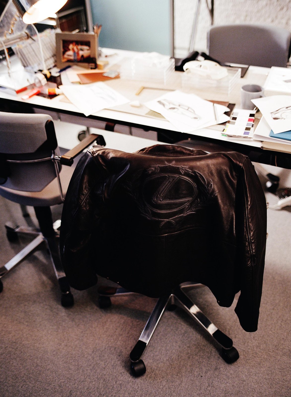 AMBUSH Lexus leather fireman jacket with embossed crest on office chair