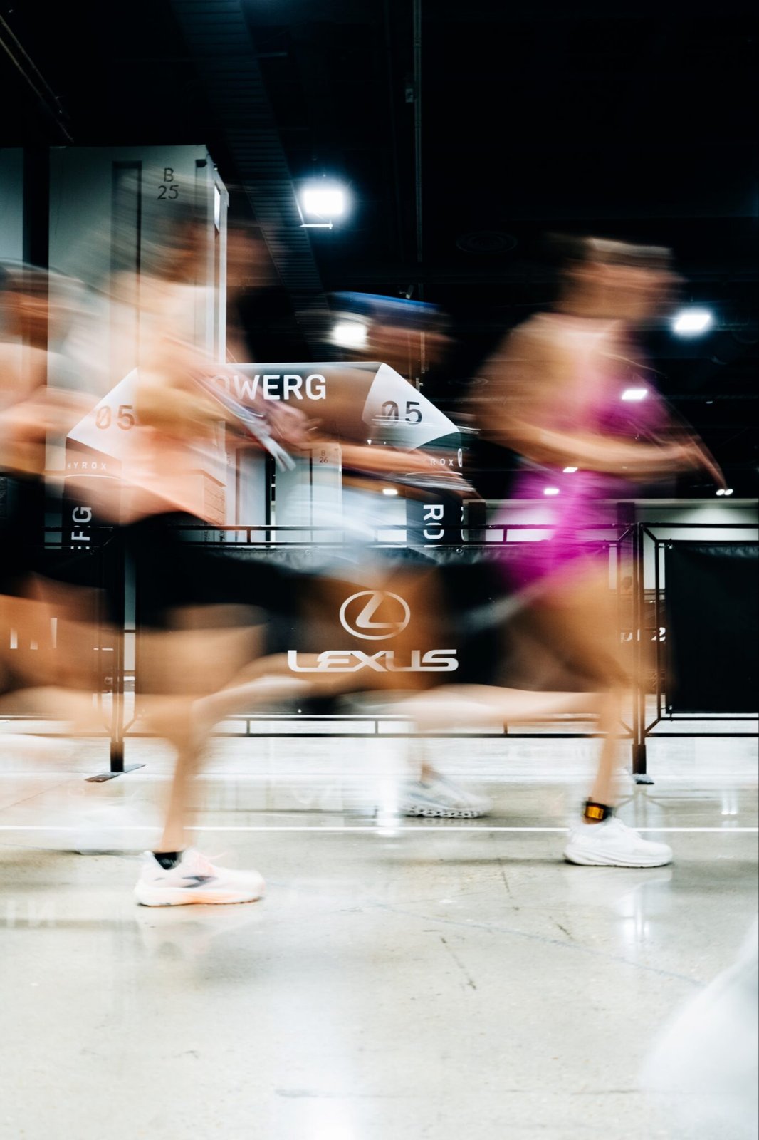 Athletes at HYROX rowing station with Lexus signage