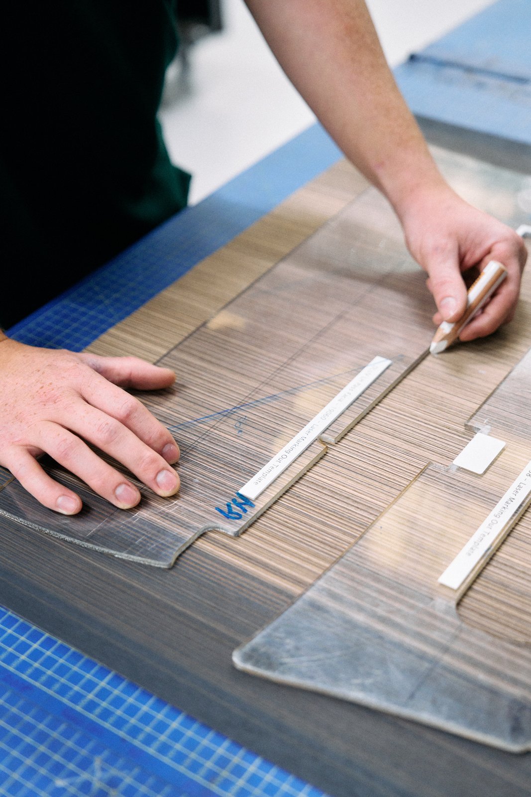 Craftsperson marking out veneer with a template at Bentley Crewe