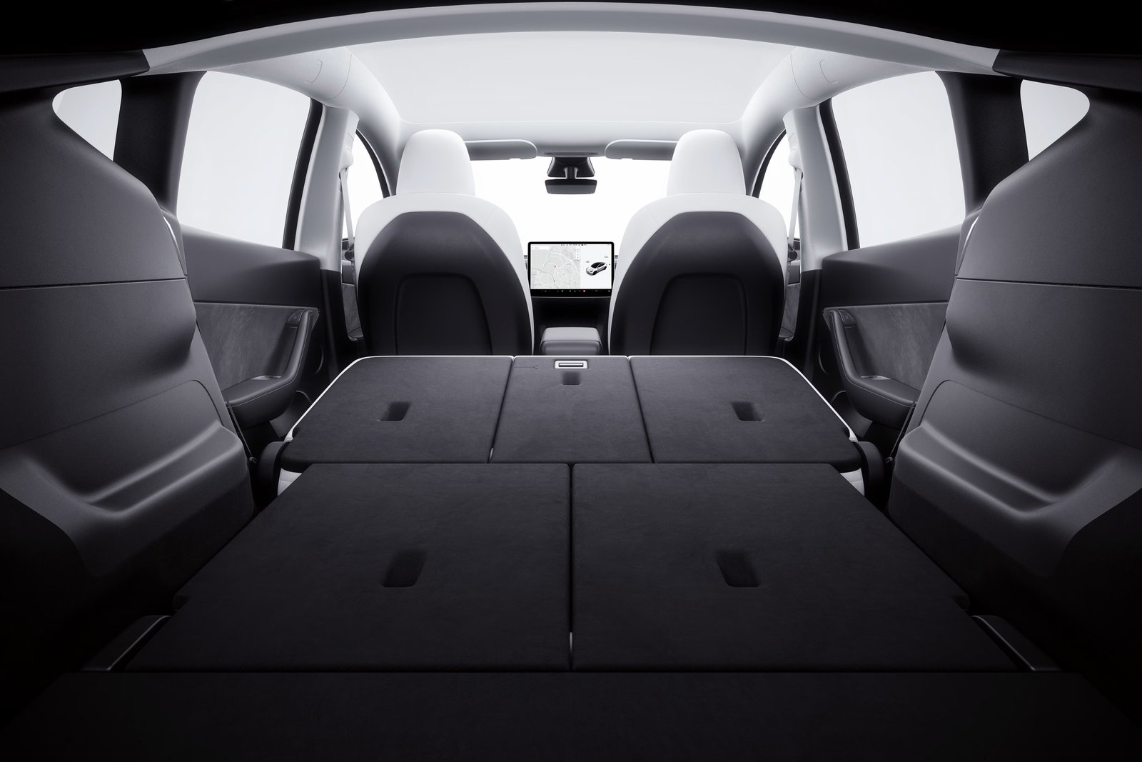 Tesla Model Y cabin with rear seats folded and central touchscreen