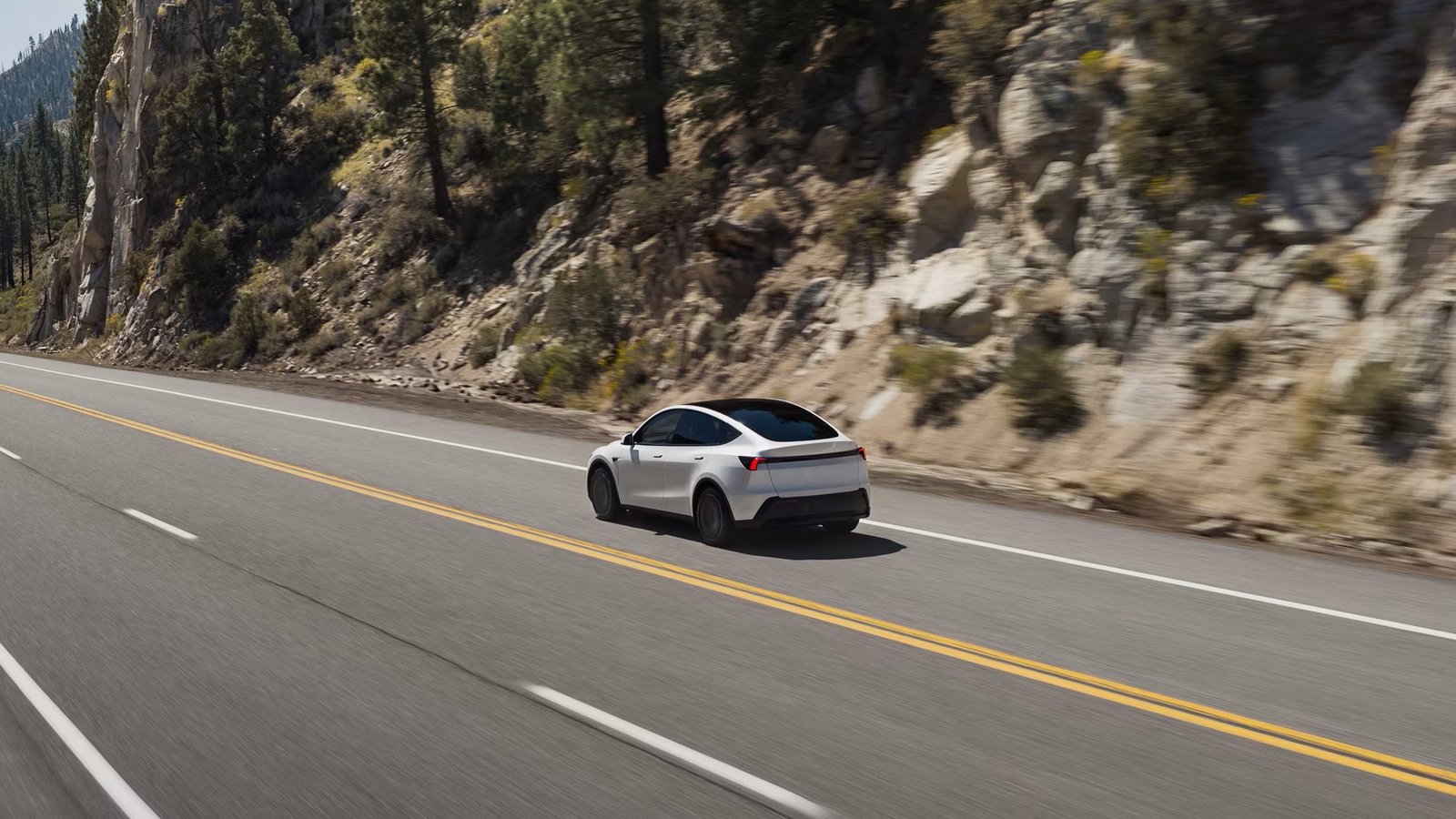 2026 Tesla Model Y driving on a mountain highway