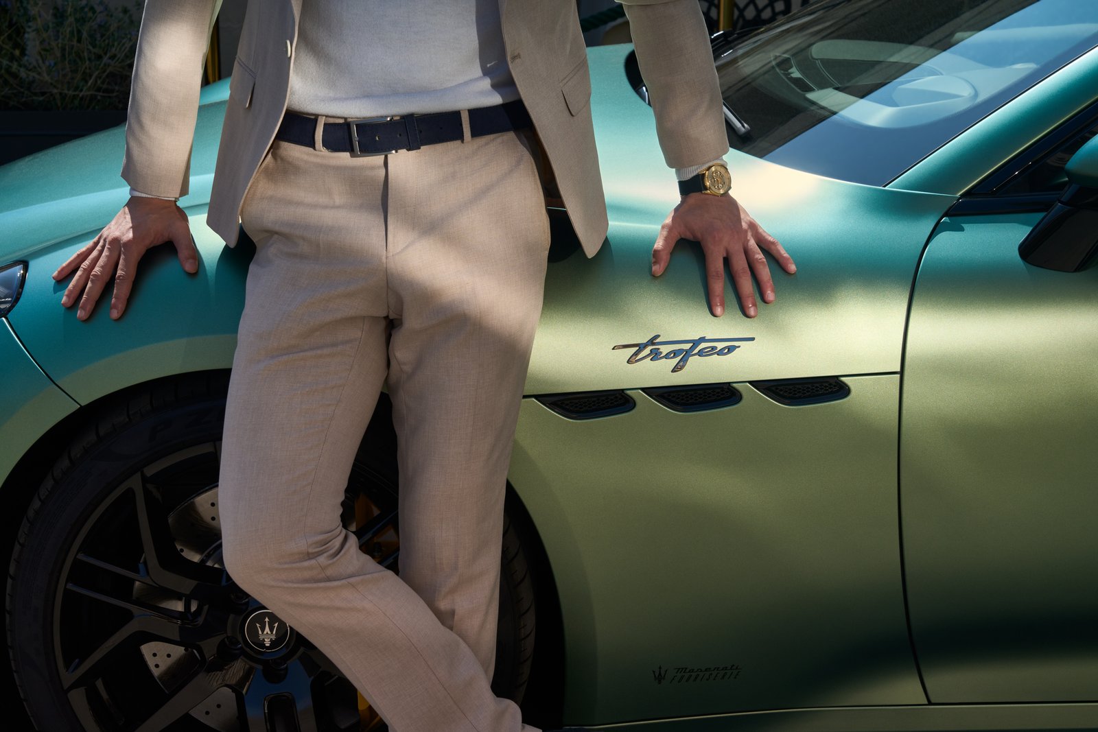 Man in tailored suit leaning on Maserati GranTurismo Trofeo