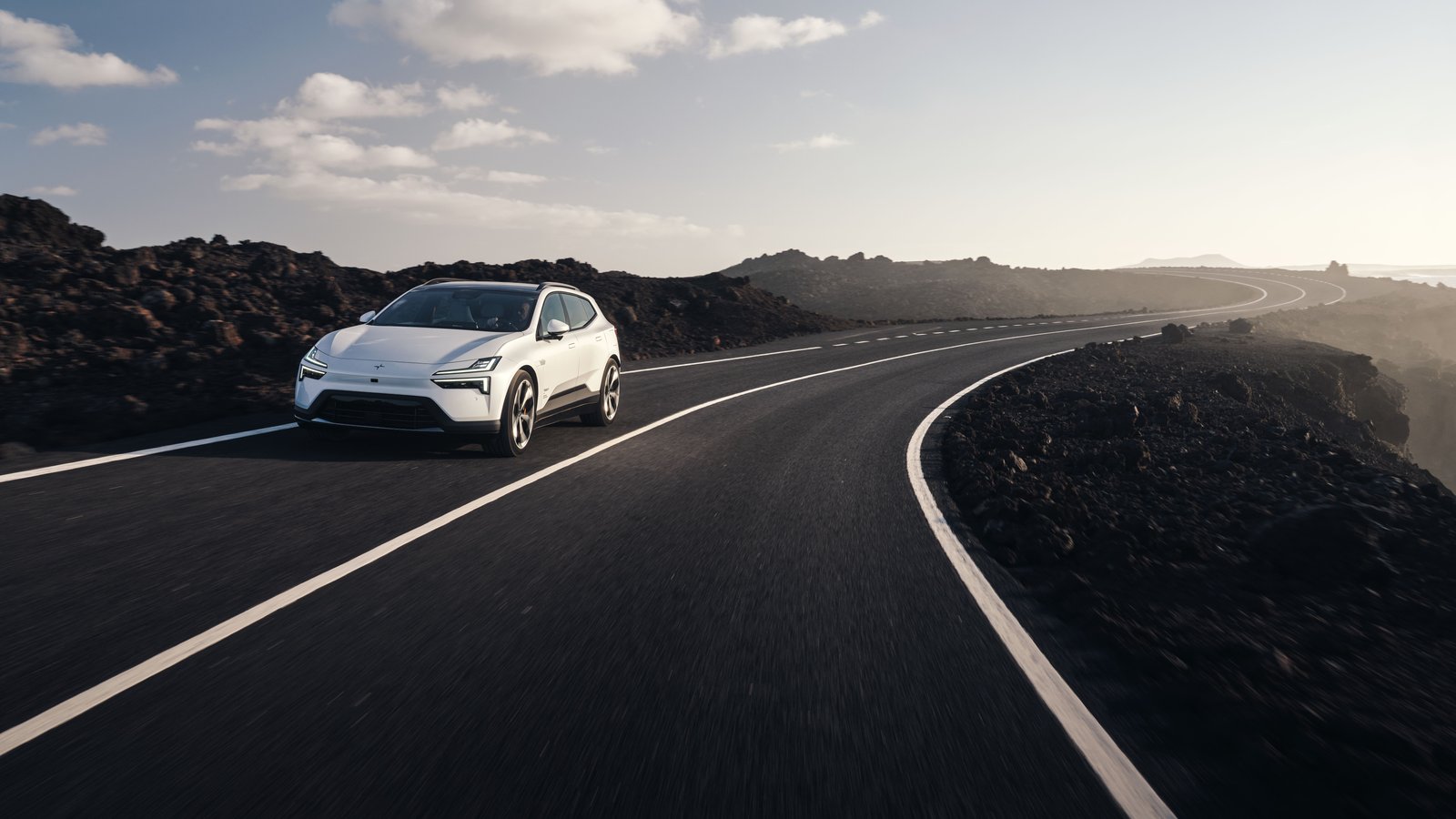 White Polestar 4 SUV driving on a coastal road