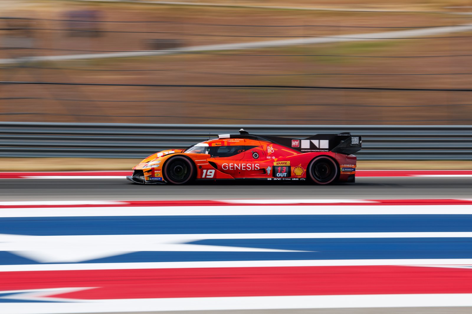Side view of the Genesis GMR-001 #19 at speed at COTA