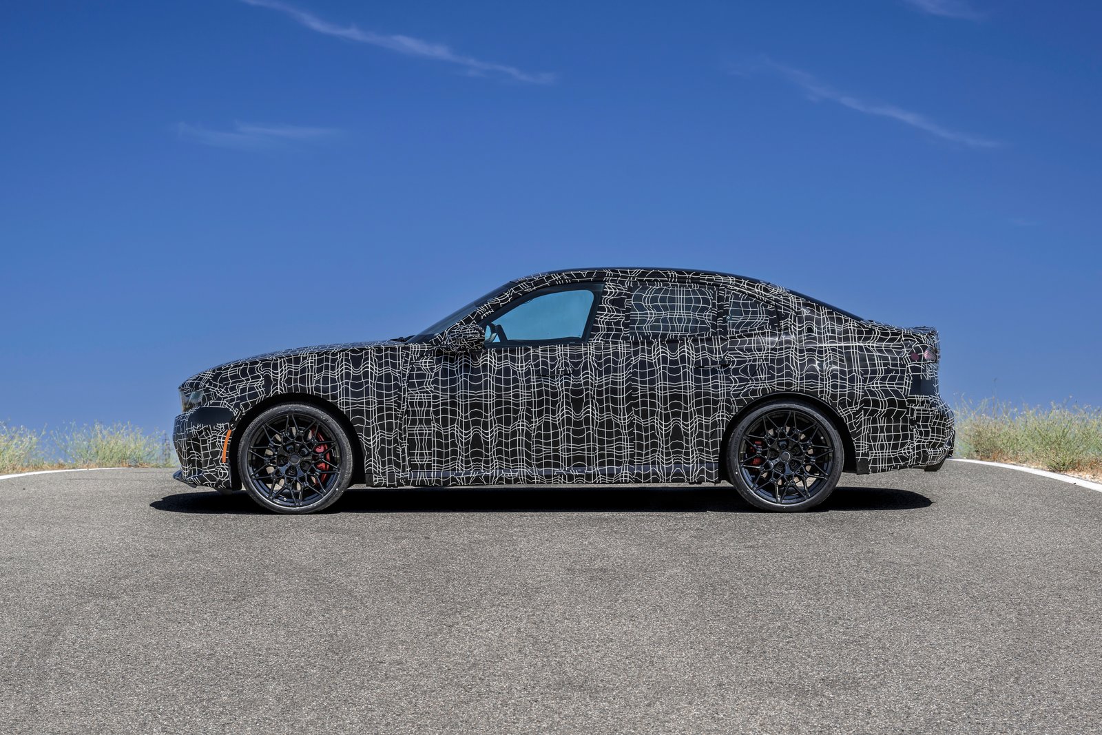 Side profile of camouflaged new BMW 3 Series prototype on 20-inch wheels