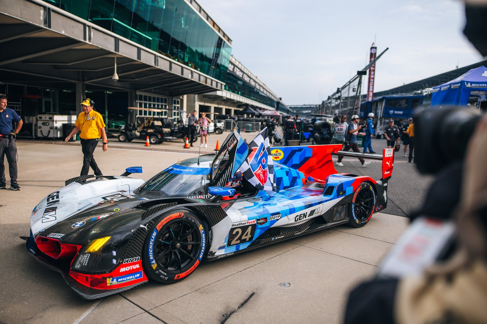 Winning No. 24 BMW M Hybrid V8 carrying the checkered flag in pit lane