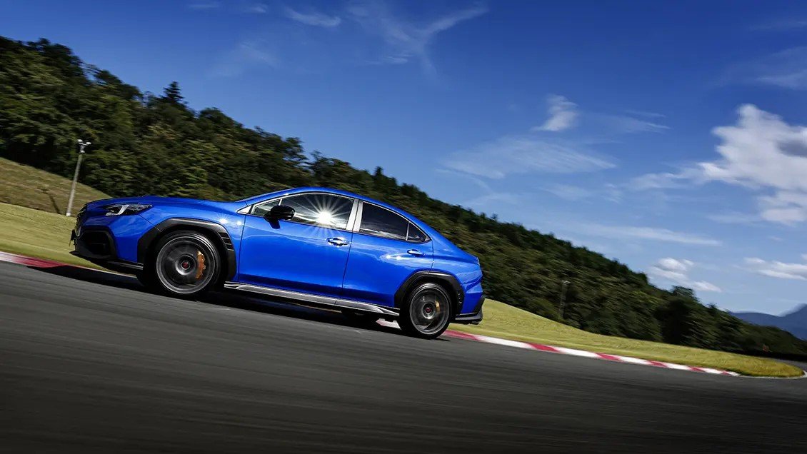 Blue Subaru WRX STI Sport sedan driving on a racetrack