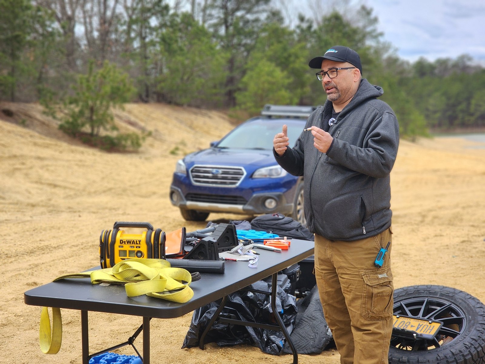 Subaru ambassador explains off-road recovery gear at a sandy trail site