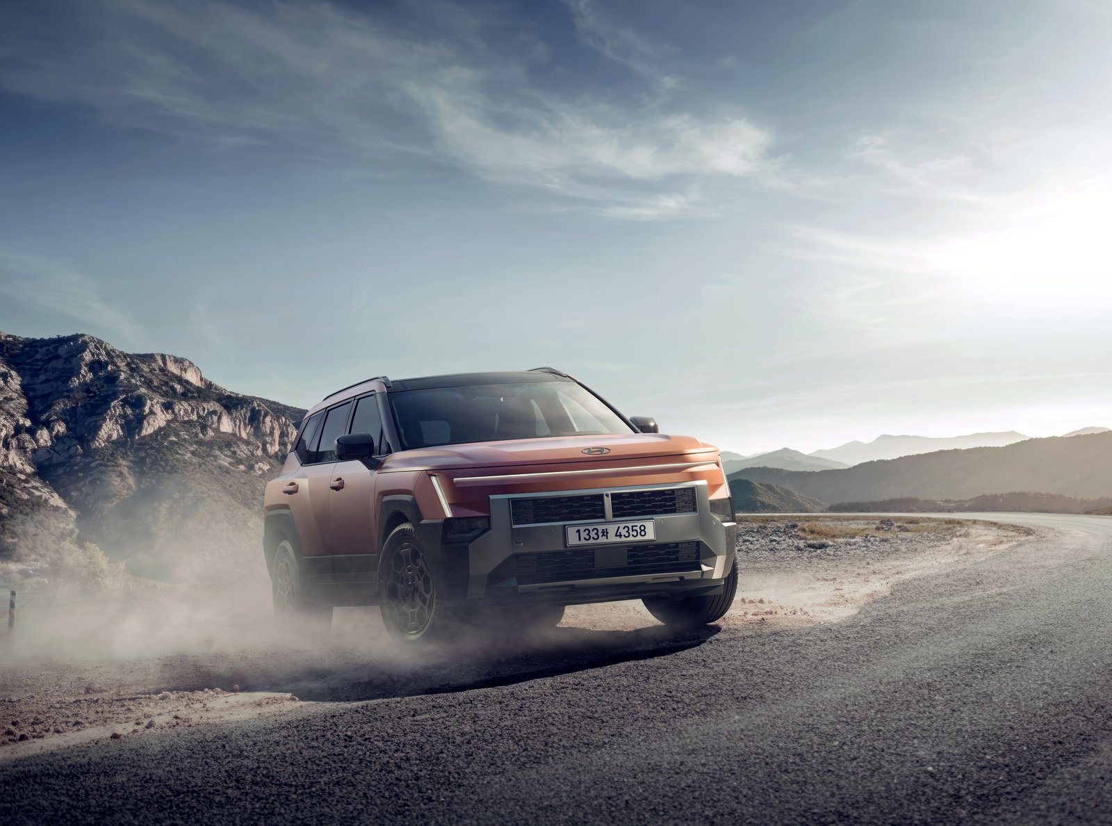 Hyundai Tucson XRT in orange driving on a gravel road