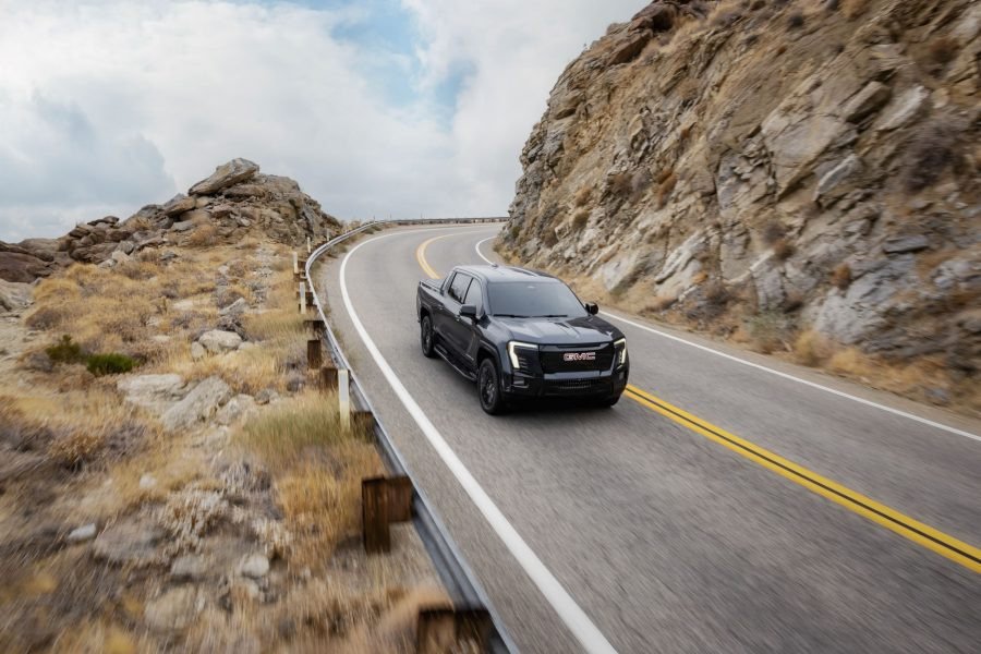 2026 GMC Sierra EV driving on a mountain road