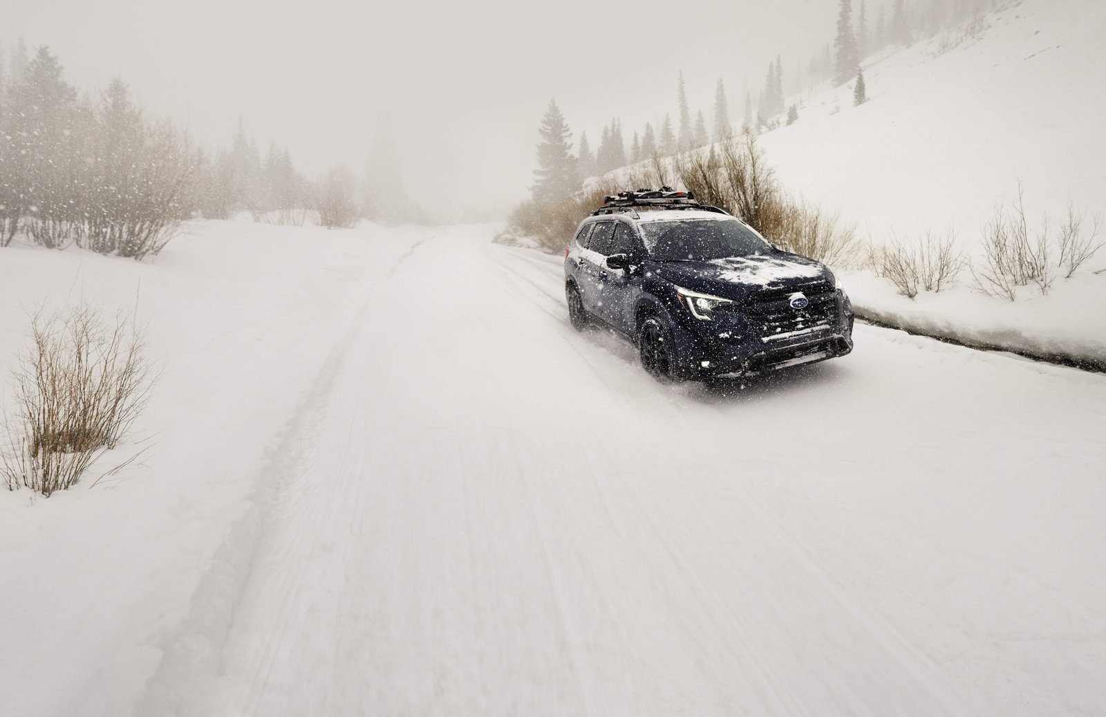 Subaru Ascent driving through heavy snowfall on an unplowed road