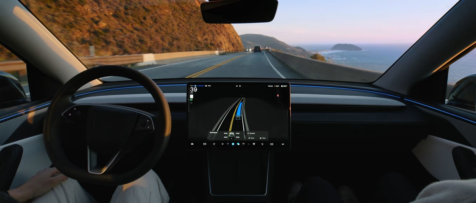 Tesla Model 3 screen showing Full Self-Driving on a coastal two-lane road